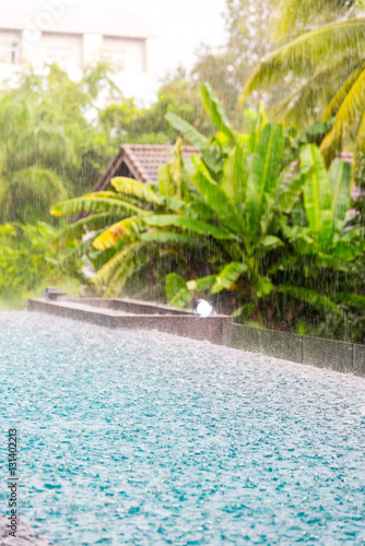 Fototapeta Naklejka Na Ścianę i Meble -  (torrent) Rain falling on surface Blue water in swimming  pool a