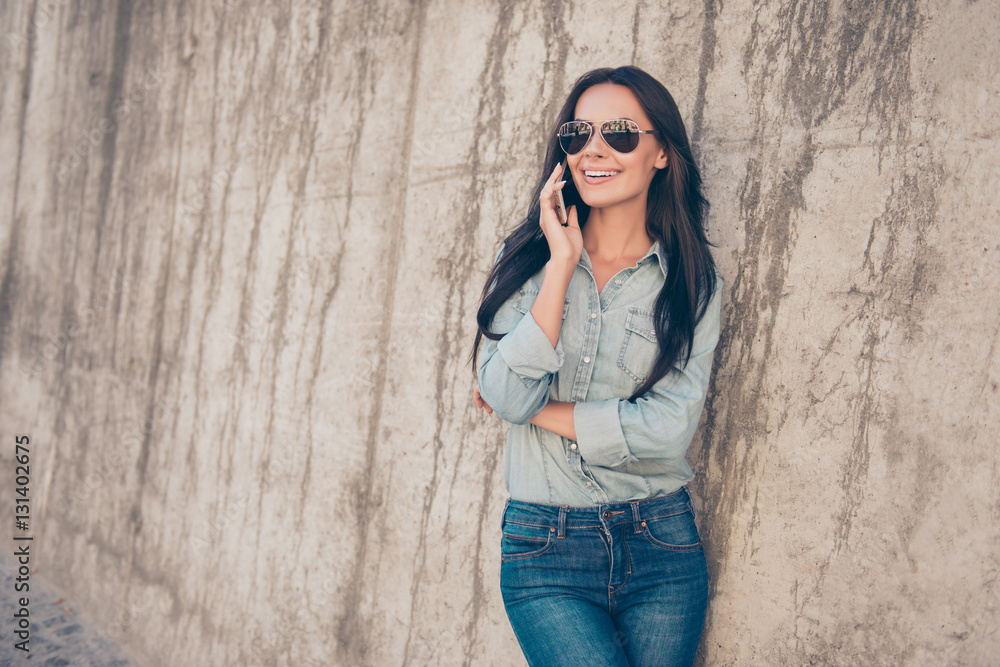 Stylish pretty brunette in glasses having conversation on phone Stylish pretty brunette in glasses having conversation on phone