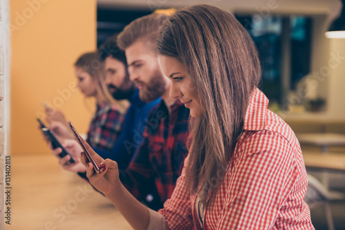 Group of students typing messages on smartphones to friends