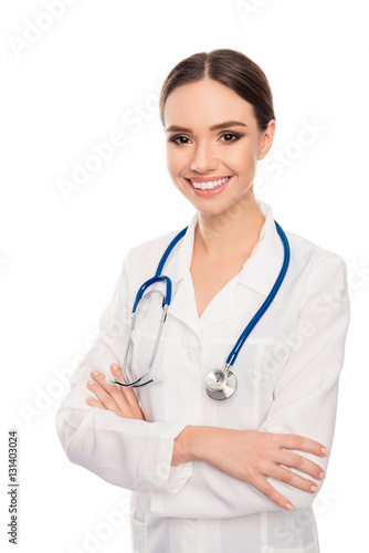 Portrait of pretty female doctor with beaming smile and crossed