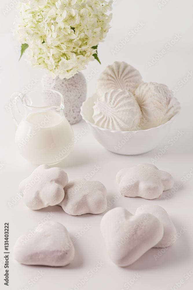 On a white background cakes, desserts, sweets, milk, flowers. Dairy products and sweets in the high key. Studio light. Place for text. On a white background cakes, desserts, sweets, milk, flowers. Dairy products and sweets in the high key. Studio light. Place for text.