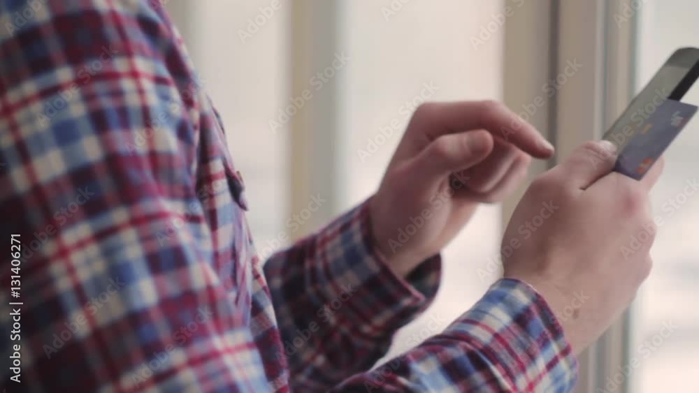 Young man online banking using smartphone shopping online with credit card at home lifestyle Young man online banking using smartphone shopping online with credit card at home lifestyle
