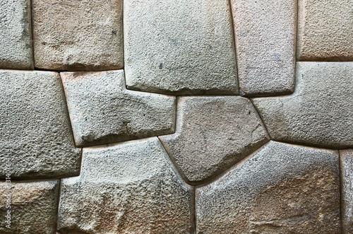 The multi-sided granite stones in ancient Inca wall street Hatunrumiyoc - Cusco, Peru photo