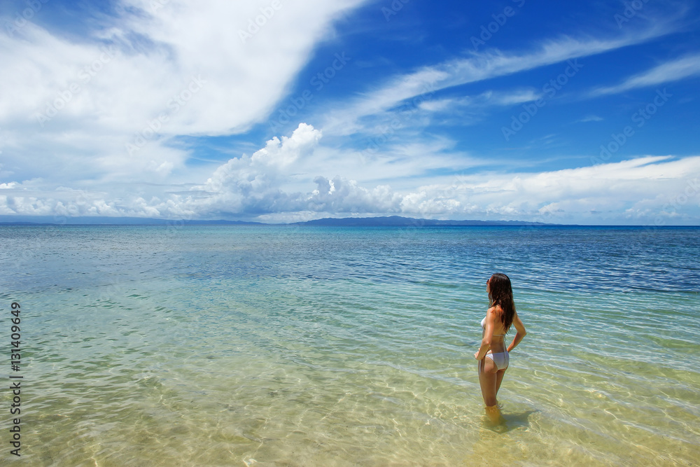 Young woman in bikini standing in clear water on Taveuni Island,