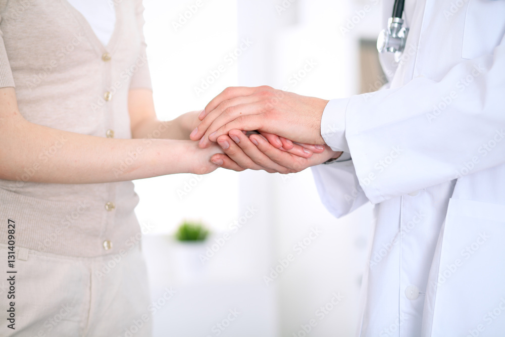 Hand of doctor reassuring her female patient Hand of doctor reassuring her female patient