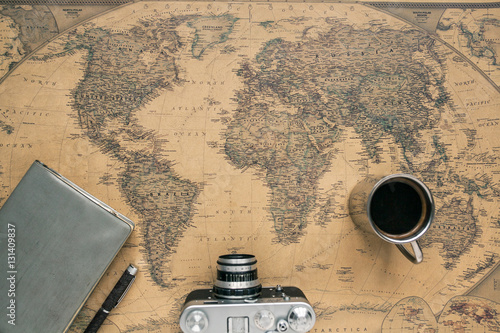 Fotografie Vintage Camera, Notebook, Pen, Metal Coffee Cup on Retro World Map