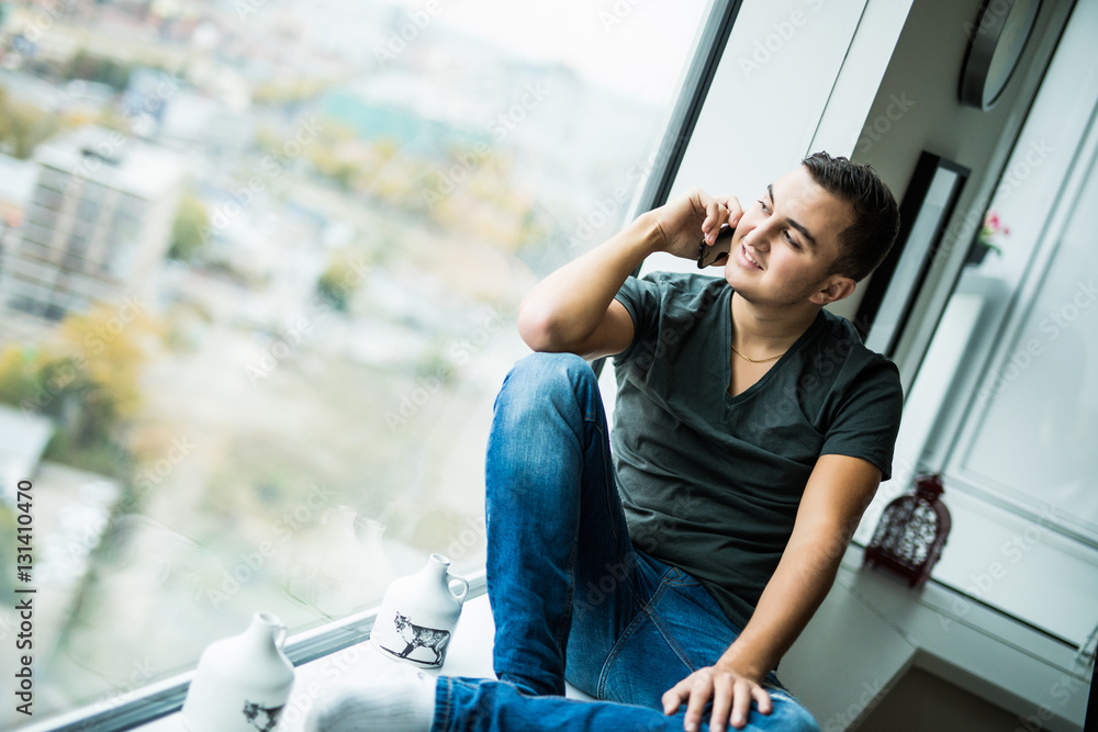 Young man use phone on panoramic window Young man use phone on panoramic window