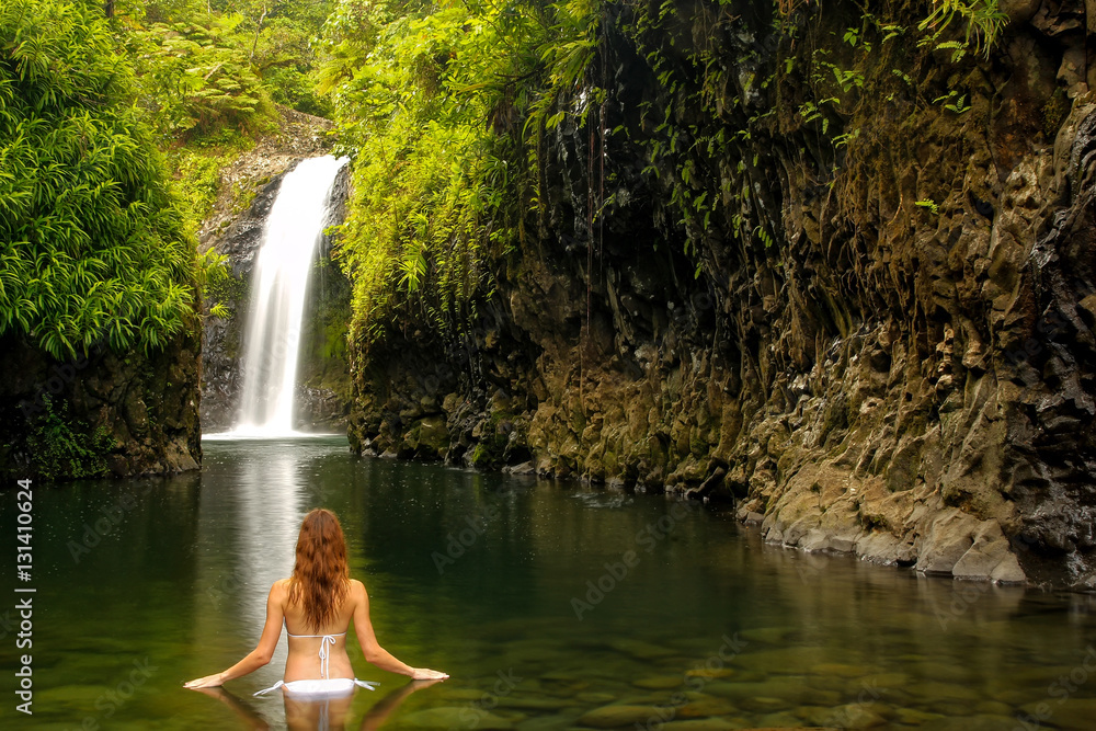 Fototapeta premium Young woman in bikini standing at Wainibau Waterfall on Taveuni