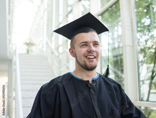 Young male student in black graduation gown