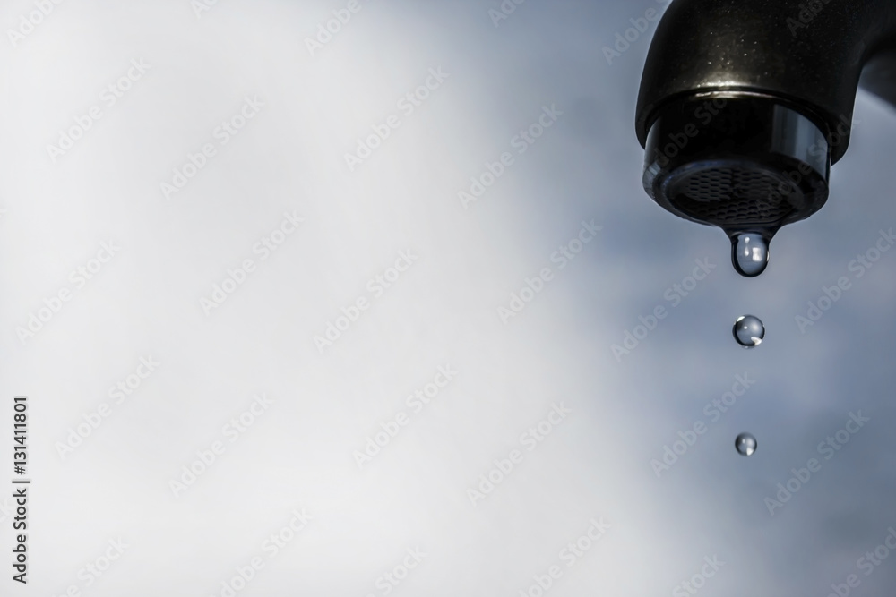 last drops of water from tap isolated on blue background last drops of water from tap isolated on blue background