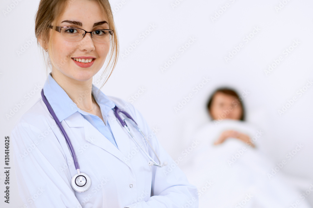 Female doctor smiling on the background with patient and his doctor Female doctor smiling on the background with patient and his doctor