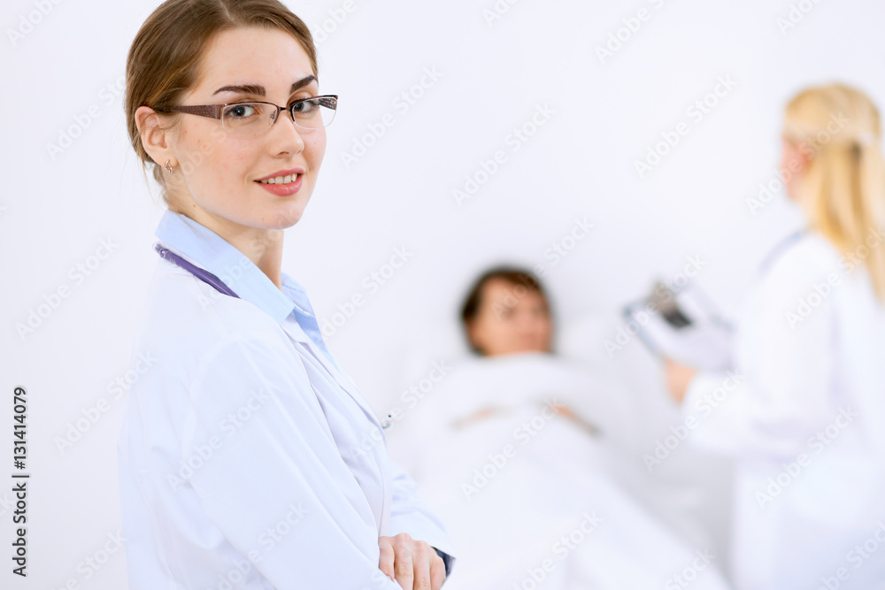 Female doctor smiling on the background with patient and his doctor Female doctor smiling on the background with patient and his doctor