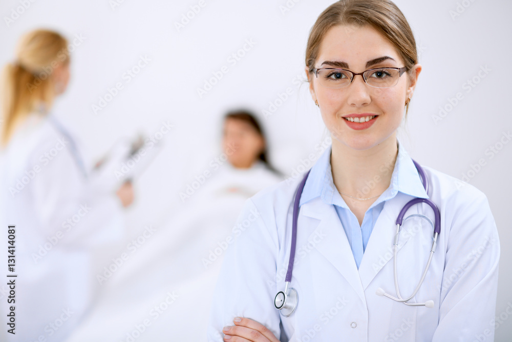 Female doctor smiling on the background with patient and his doctor Female doctor smiling on the background with patient and his doctor