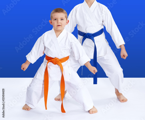 Two athletes on a blue background in the rack of karate