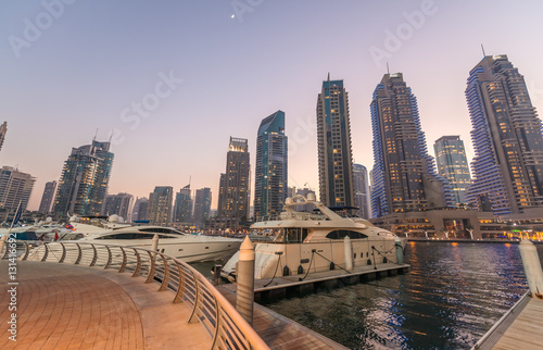 Sunset in Dubai Marina. Buildings reflections over artificial ca