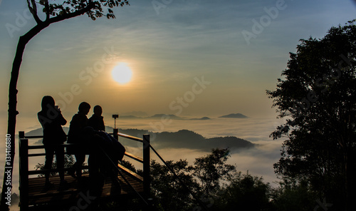 Silhouettes of tourists on viewpoint with the mountain in mornin