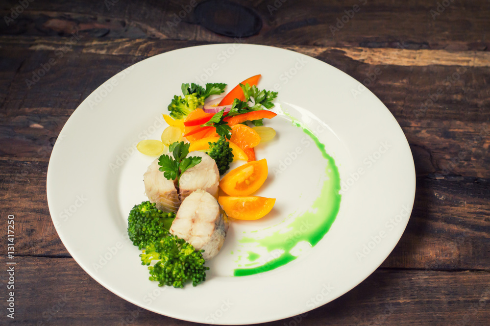 Boiled seabass with steamed vegetables - totally healthy meal. Top view. Close-up Boiled seabass with steamed vegetables - totally healthy meal. Top view. Close-up