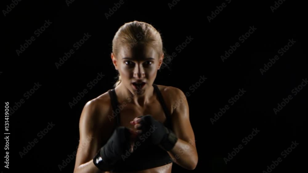 Boxer girl makes blows by hands and by feet Boxer girl makes blows by hands and by feet