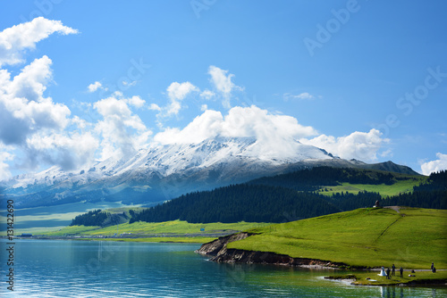 Sayram Lake with snow mountains and blue sky.