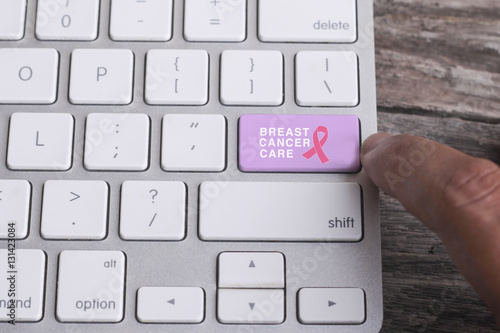 Close up of finger on keyboard button with BREAST CANCER CARE word