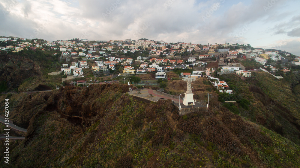 The Christ the King statue is a Catholic monument on Madeira island, Portugal aerial view The Christ the King statue is a Catholic monument on Madeira island, Portugal aerial view