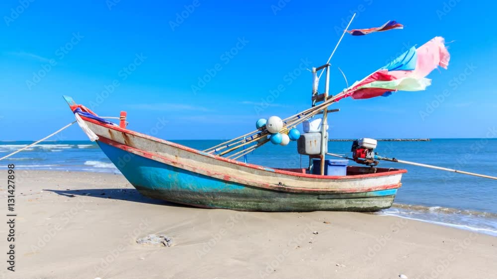 the alone fishing boat on the beach with blue sky in Thailand ocean the alone fishing boat on the beach with blue sky in Thailand ocean