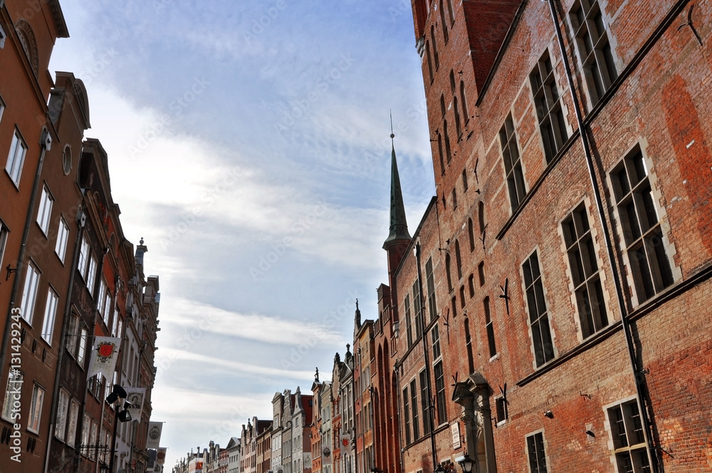 Old pedestrian street with red brick houses against the blue sky. Gdansk, Poland.