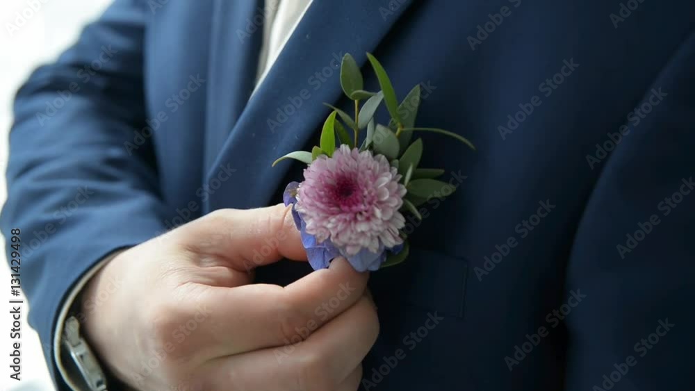 Groom in jacket corrects boutonniere Groom in jacket corrects boutonniere