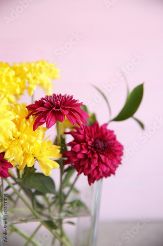 Glass vase with bouquet of beautiful flowers on color background