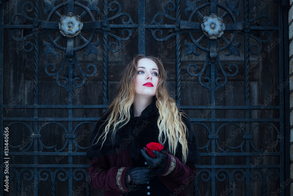 Fototapeta premium a beautiful girl standing at the lattice wrought