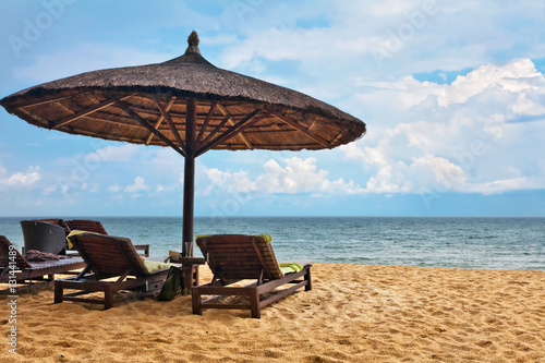 Fototapeta Naklejka Na Ścianę i Meble -  Wooden chairs and umbrellas on white sand beach