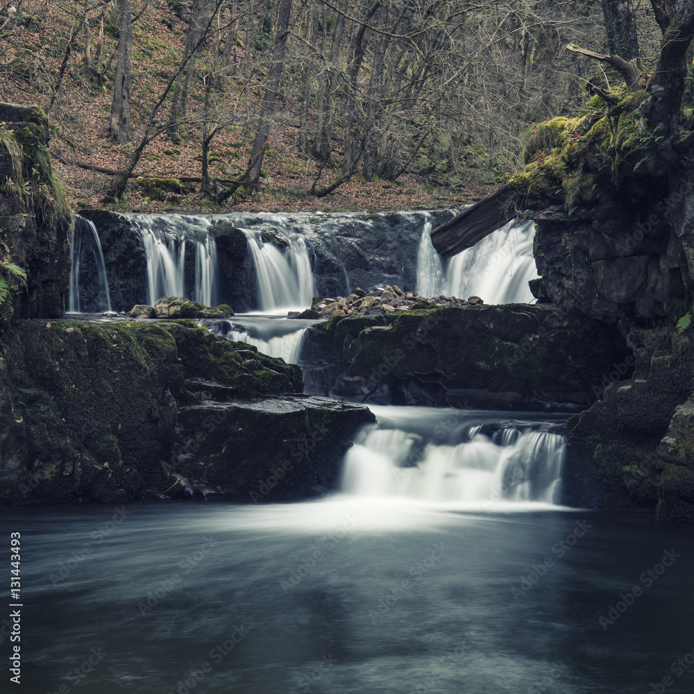 Naklejka premium Beautiful waterfall landscape image in forest during Autumn Fall