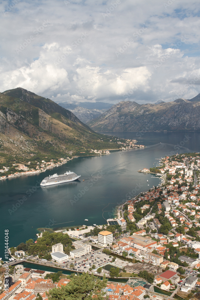 Top view of a white cruise ship in the Bay of Kotor, mountains and the city. Montenegro