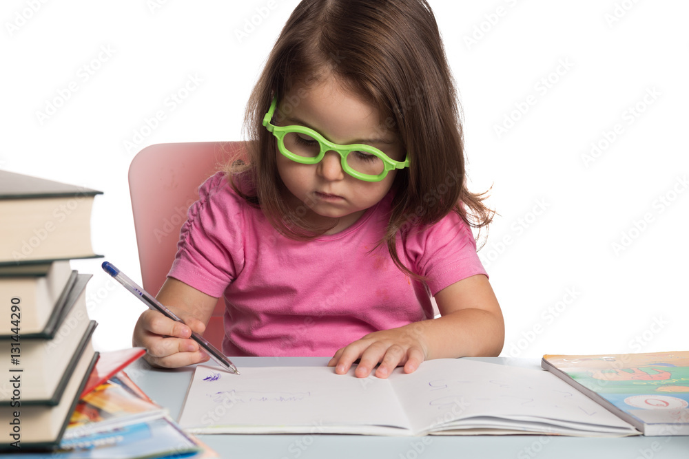 Small girl wearing glasses and learning how to write Small girl wearing glasses and learning how to write