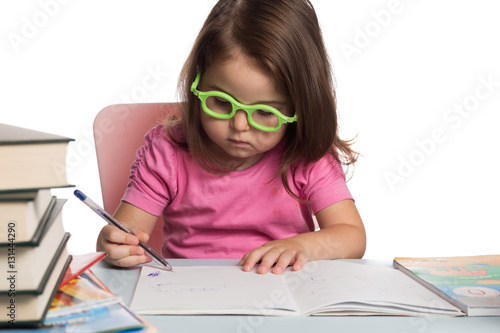 Small girl wearing glasses and learning how to write photo