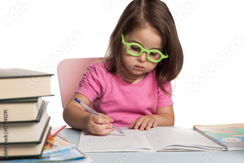 Small girl wearing glasses and learning how to write photo