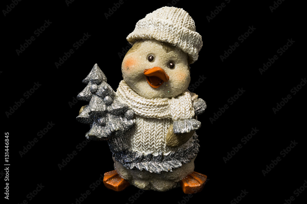 Obraz premium cute ceramic figure of penguin in knitted clothes with small pine tree, cristmas toy on black background