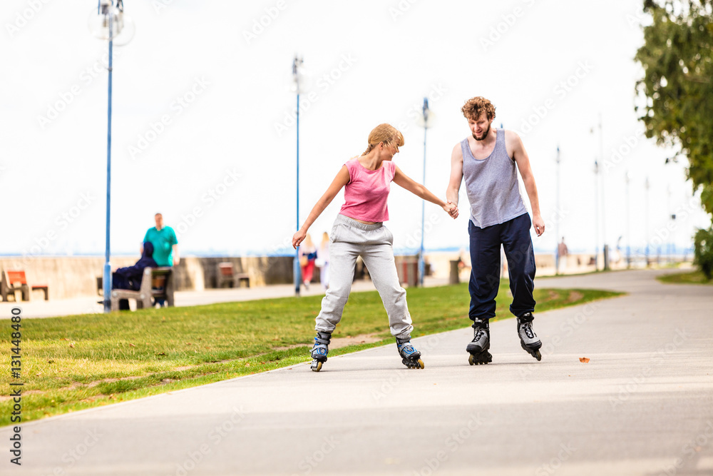 Active young people friends rollerskating outdoor.