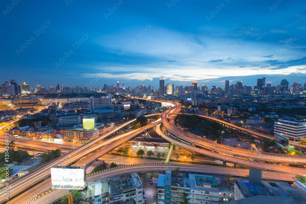 Fototapeta Aerial view highway intersection and city downtown skyline at twilight