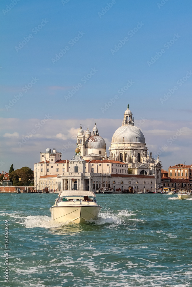 Sunny day in the Venetian lagoon, boats and temples silhouettes