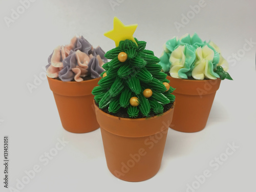 Cup cakes with bright colors like a Christmas tree and flowerpot.