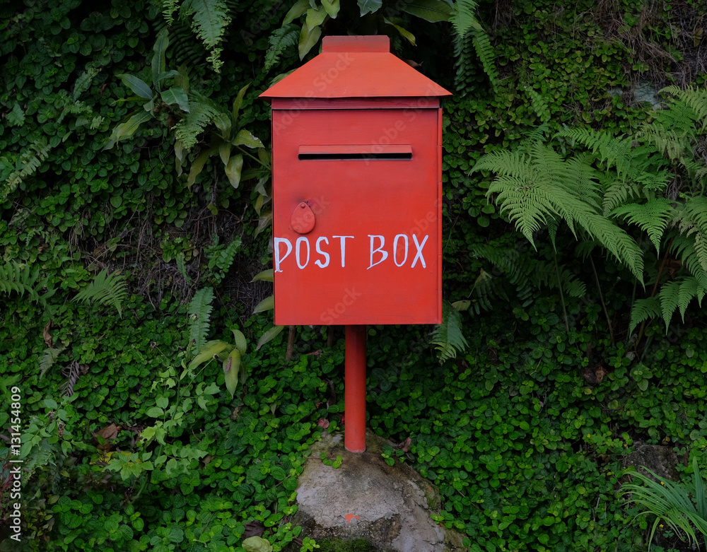 Red postbox on the natural green background Red postbox on the natural green background