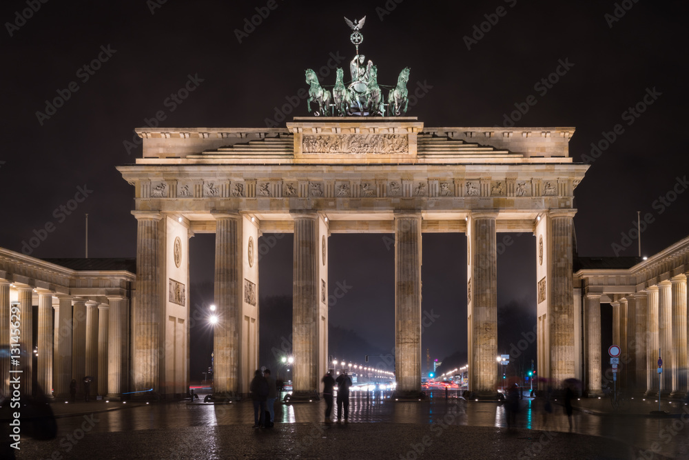 Obraz premium Tourists marvel at the Brandenburg Gate, Berlin, Germany, at night.