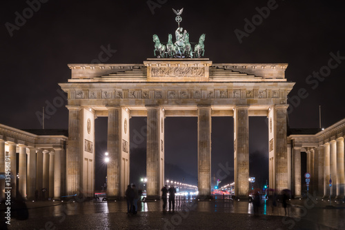 Tourists marvel at the Brandenburg Gate, Berlin, Germany, at night.