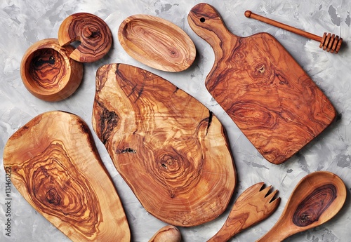 Various kitchen utensils made of olive wood - cutting boards, fork, spoon and container.