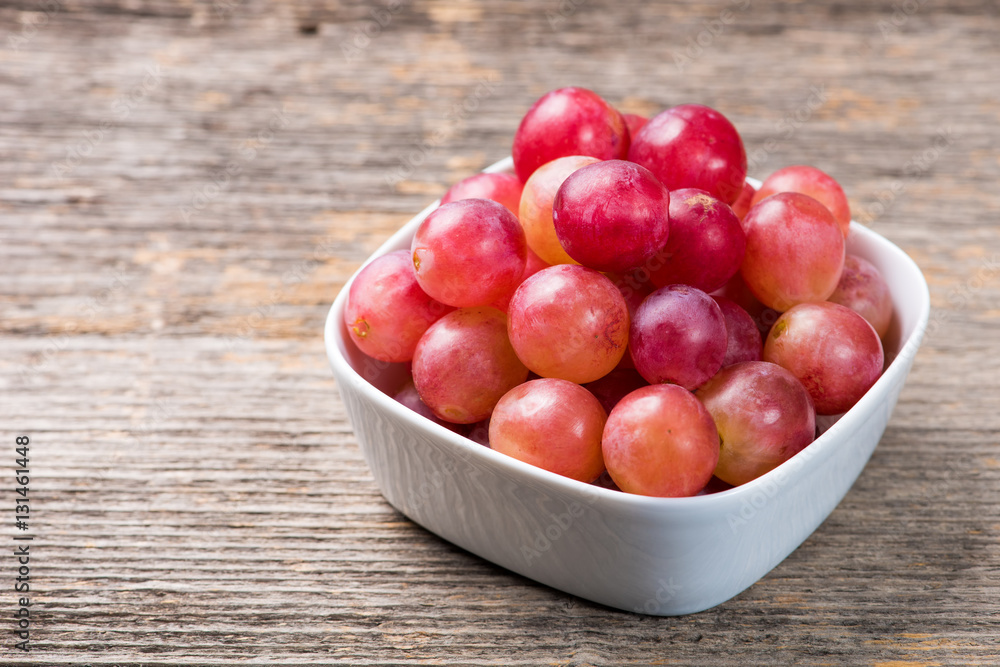 Grapes in bowl on the wooden table in natural light Grapes in bowl on the wooden table in natural light