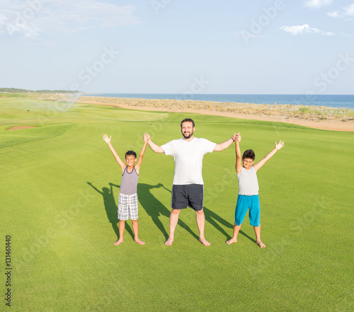Happy children on summer gulf grass terrain having fun and happy