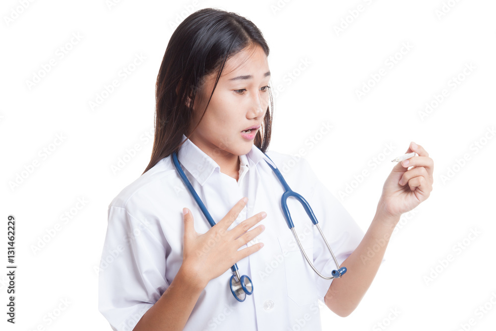 Young Asian female doctor worry look at thermometer. Young Asian female doctor worry look at thermometer.