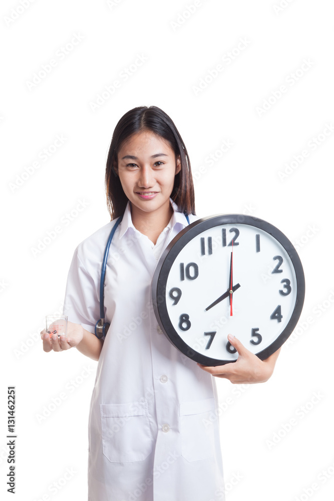 Young Asian female doctor smile with a clock and pills in hand. Young Asian female doctor smile with a clock and pills in hand.