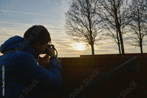 Young boy traveler photographing the sky of Brno City, Czech Republic, Europe at sunset